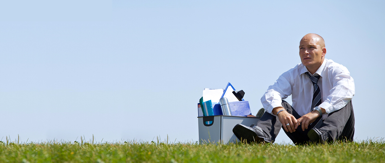 Worker sitting with a box of belongings on the side